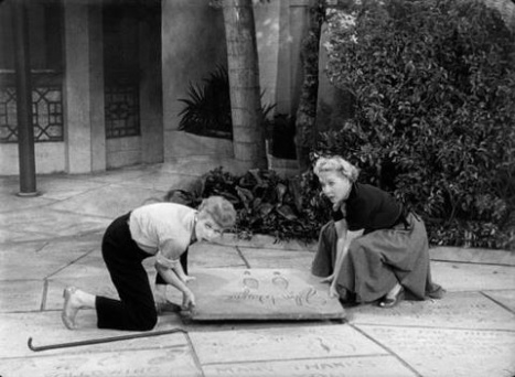 Lucy and Ethel attempting to steal John Wayne's footprints