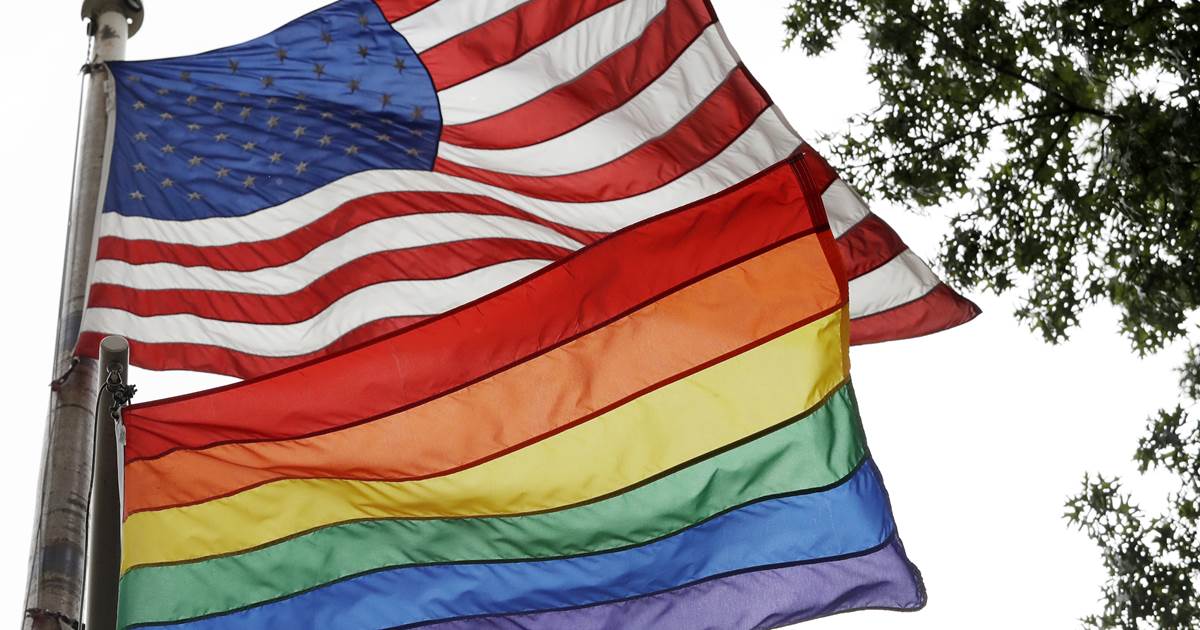 Rainbow flag flying with an American flag
