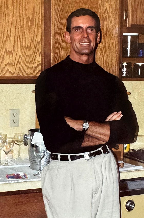 Will at age 40, smiling and posing in a kitchen