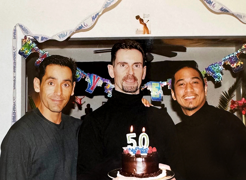 Will and two friends posing with a 50th birthday cake