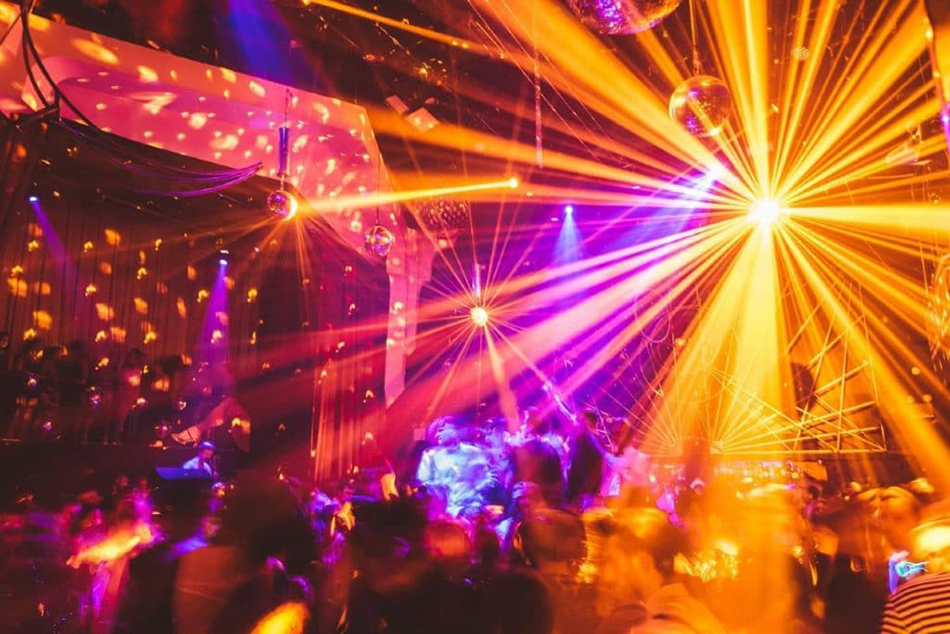 Bright orange and pink quintessential disco lighting in a nightclub.
