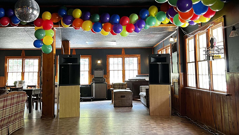 Disco ball and colorful balloon-decorated empty bar with two large speakers