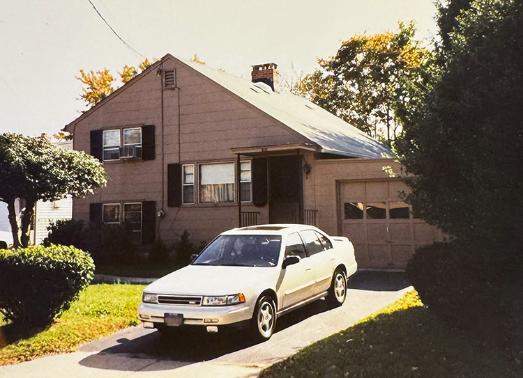 Car parked in the driveway of a house, circa 1989/1990.