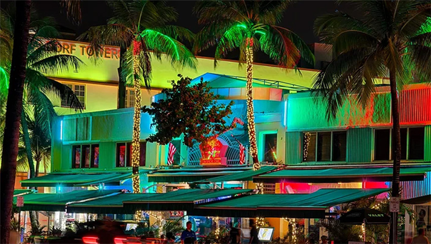 Night view of South Beach buildings brightly lit in neon colors
