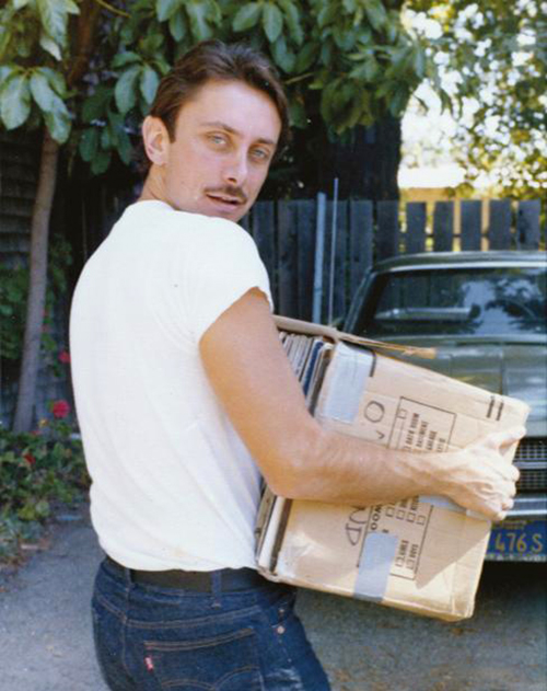 Steve Fabus carrying a stack of vinyl records